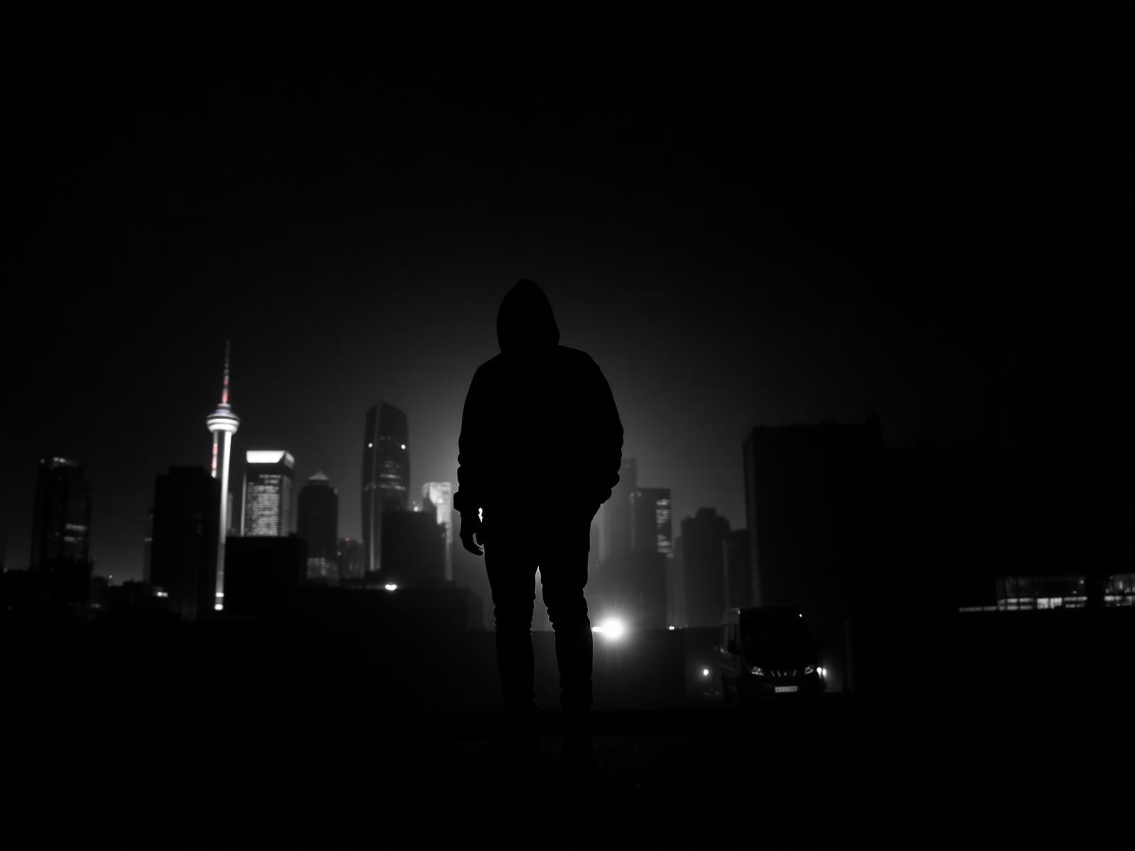 Figure against a city skyline at night